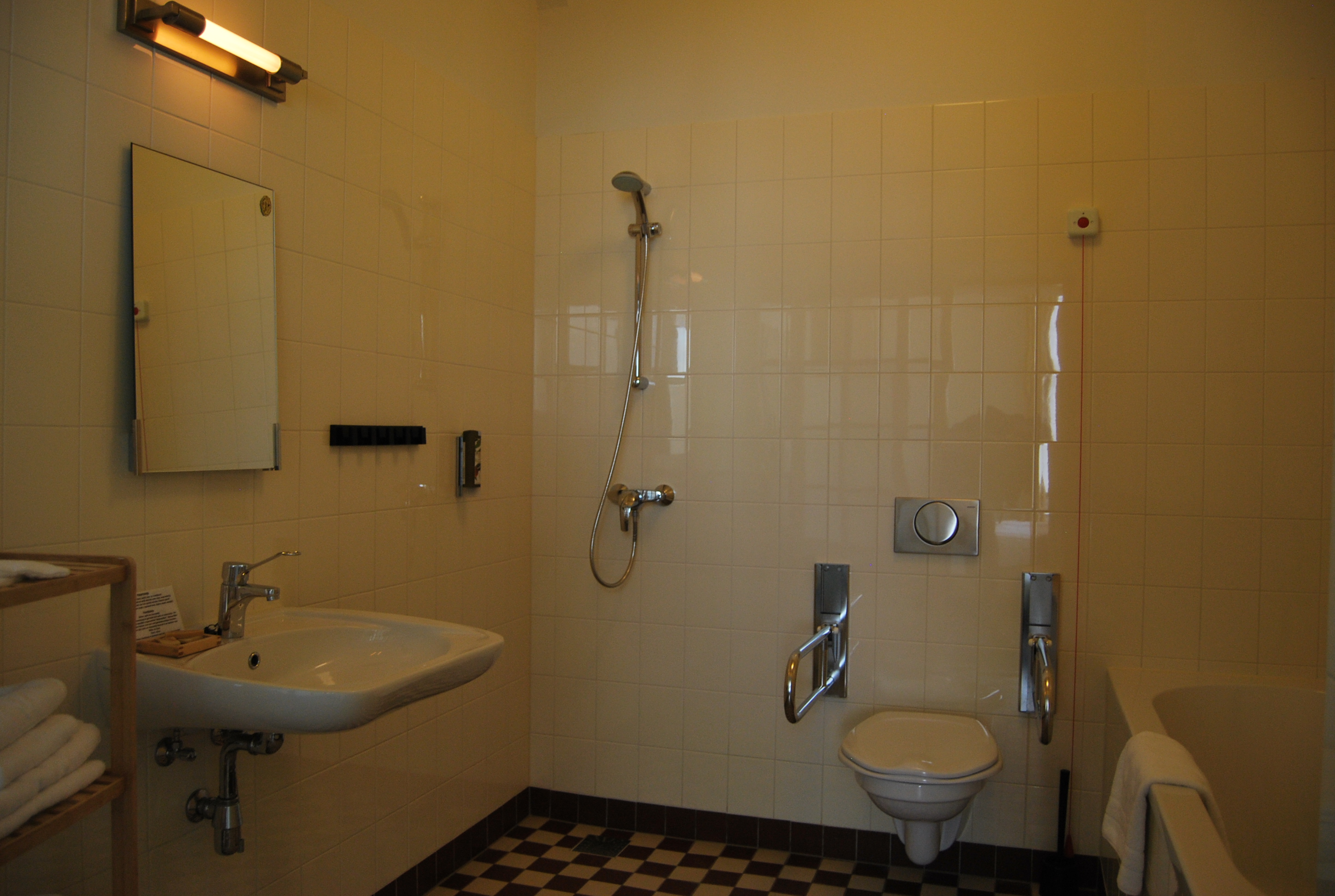een afbeelding van een aangepaste badkamer voor mindervaliden, welke rolstoeltoegangelijk is. 